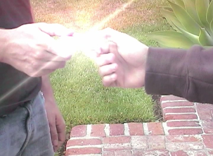 Two hands exchanging a glowing object